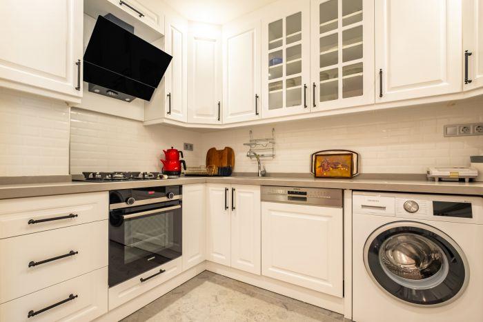 Every equipment is ready for your use in this white kitchen.